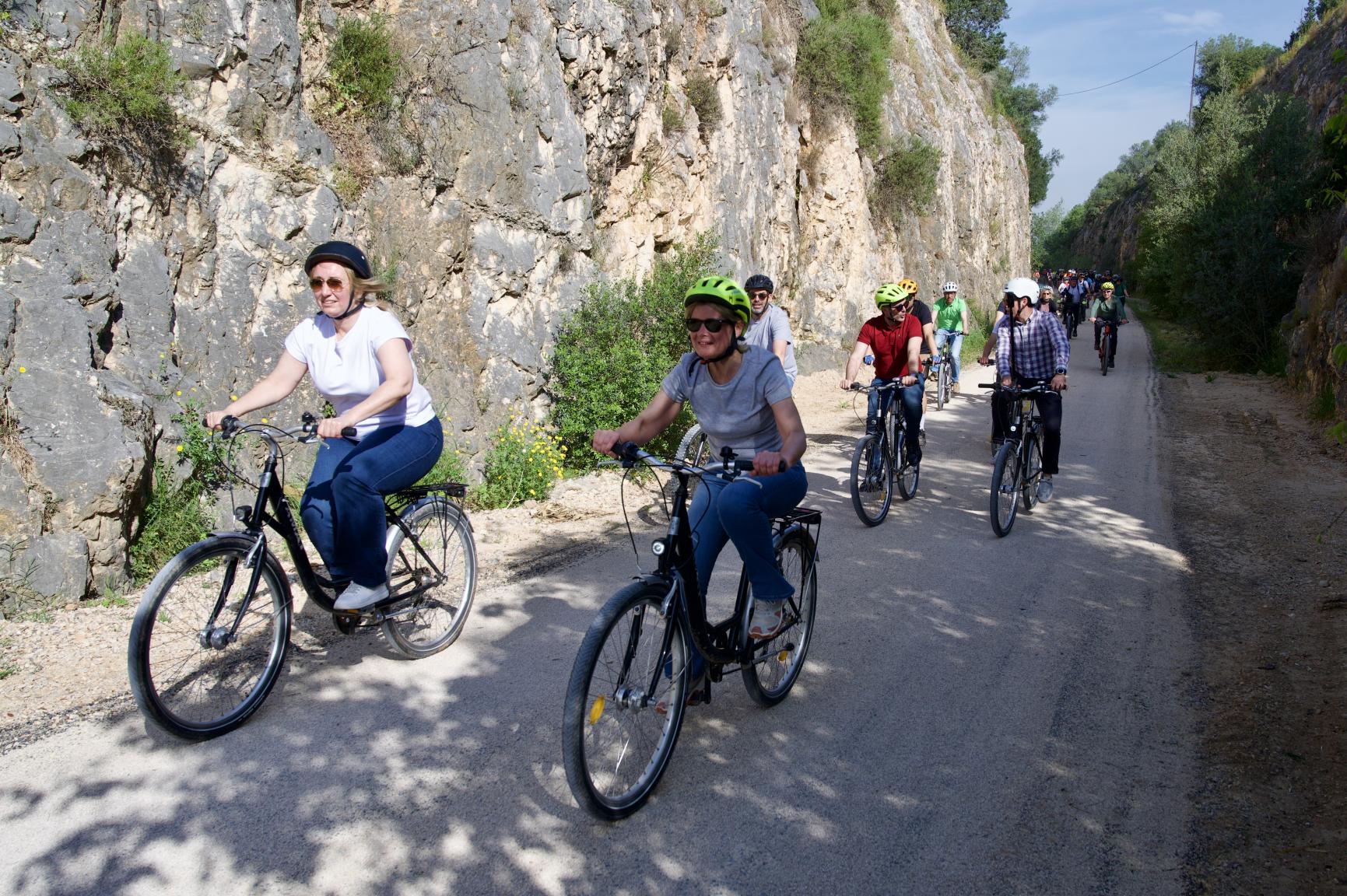 Fotografia de la presidenta de la Diputació en bicicleta, acompanyada per altres autoritats i ciutadans